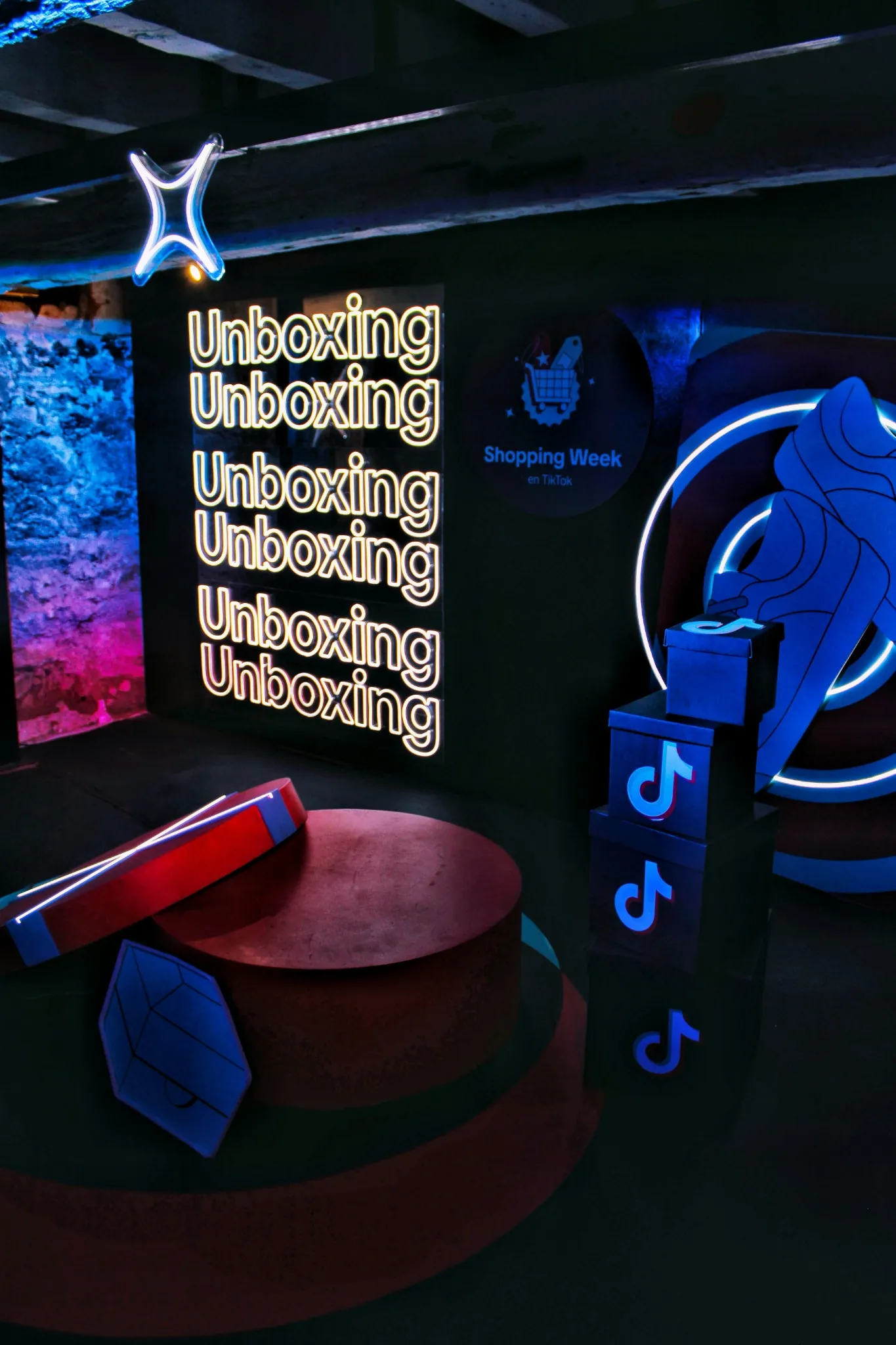 Neon 'Unboxing' signs and branded boxes at a TikTok Shopping Week brand activation